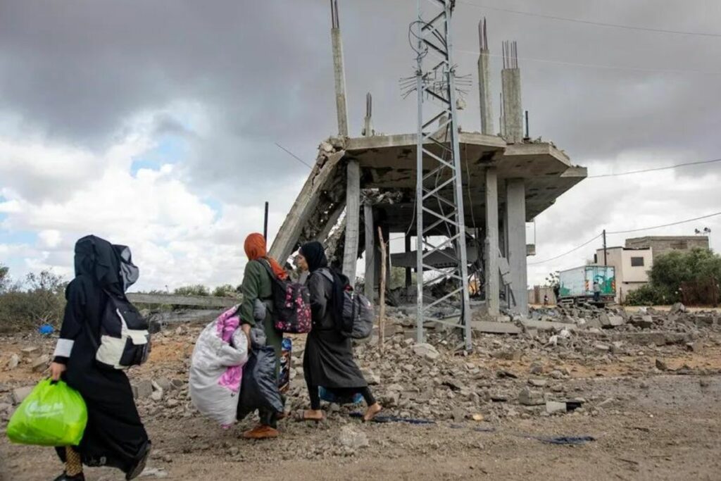 Mujeres palestinas caminan con sus pertenencias después de la orden de evacuación emitida por el ejército israelí, en Rafah,