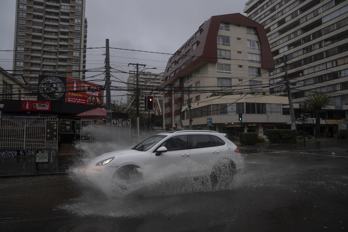 Un vehículo transita por una avenida durante un clima lluvioso, este jueves en Valparaíso (Chile).