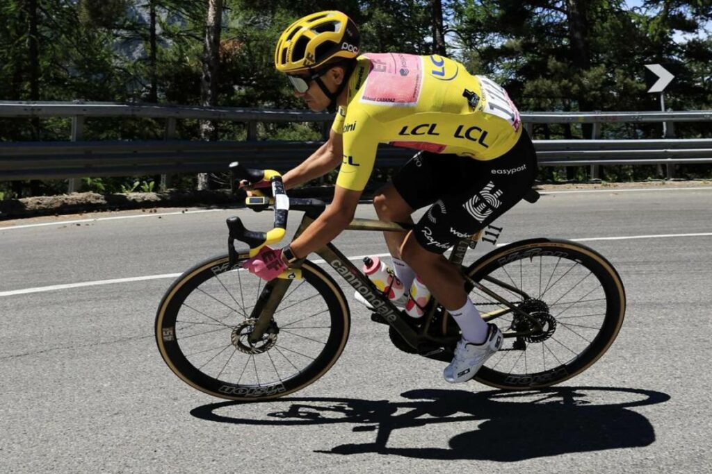 Richard Carapaz defiende el liderato del Tour de Francia 2024 sobre una bicicleta dorada con detalles amarillos.