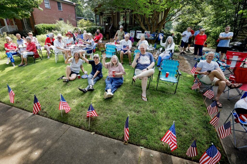 Personas en un patio delantero mientras observan el desfile del 4 de julio en Avondale Estates, Georgia, EE. UU.